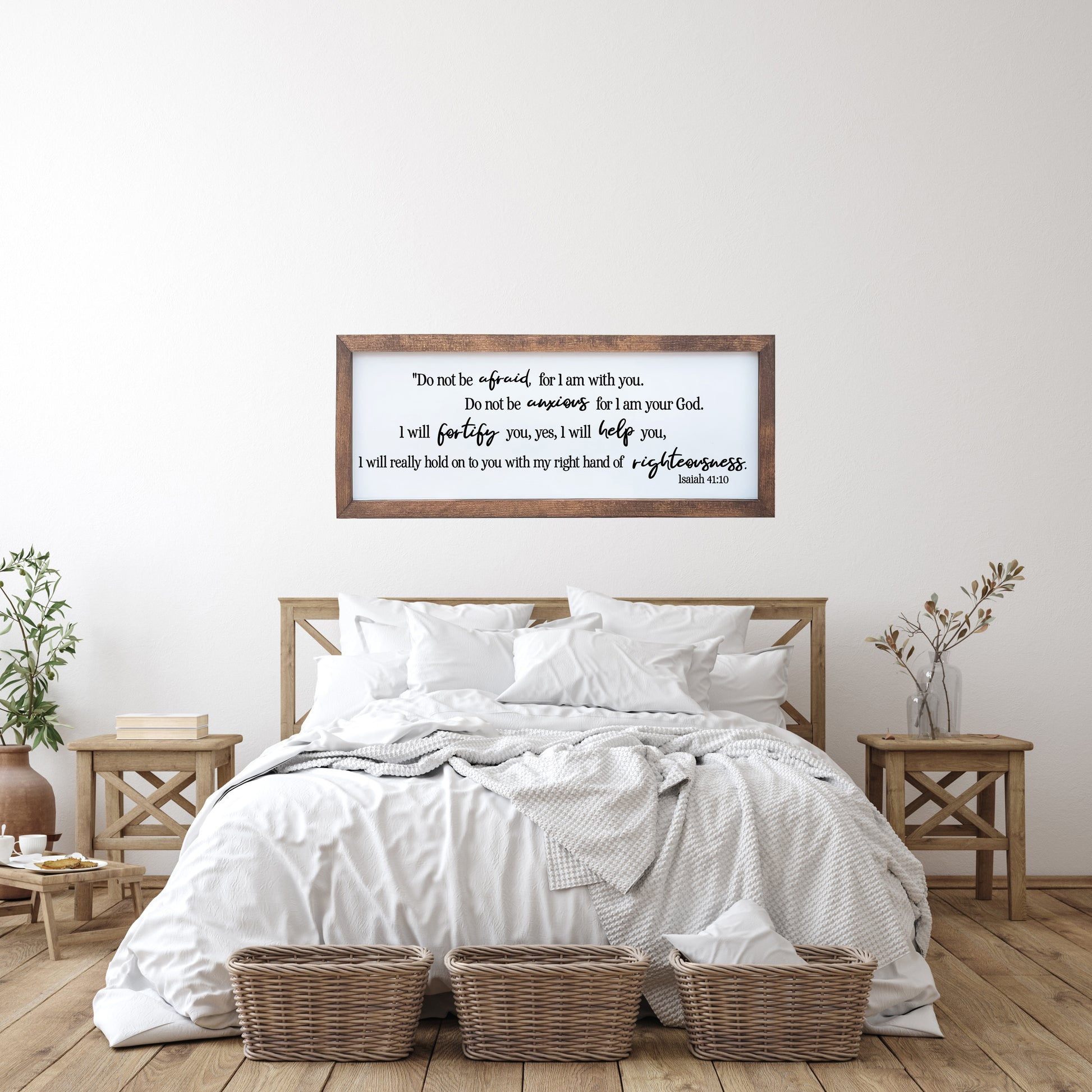 Bedroom with wooden headboard, white bedding, and framed text on wall.