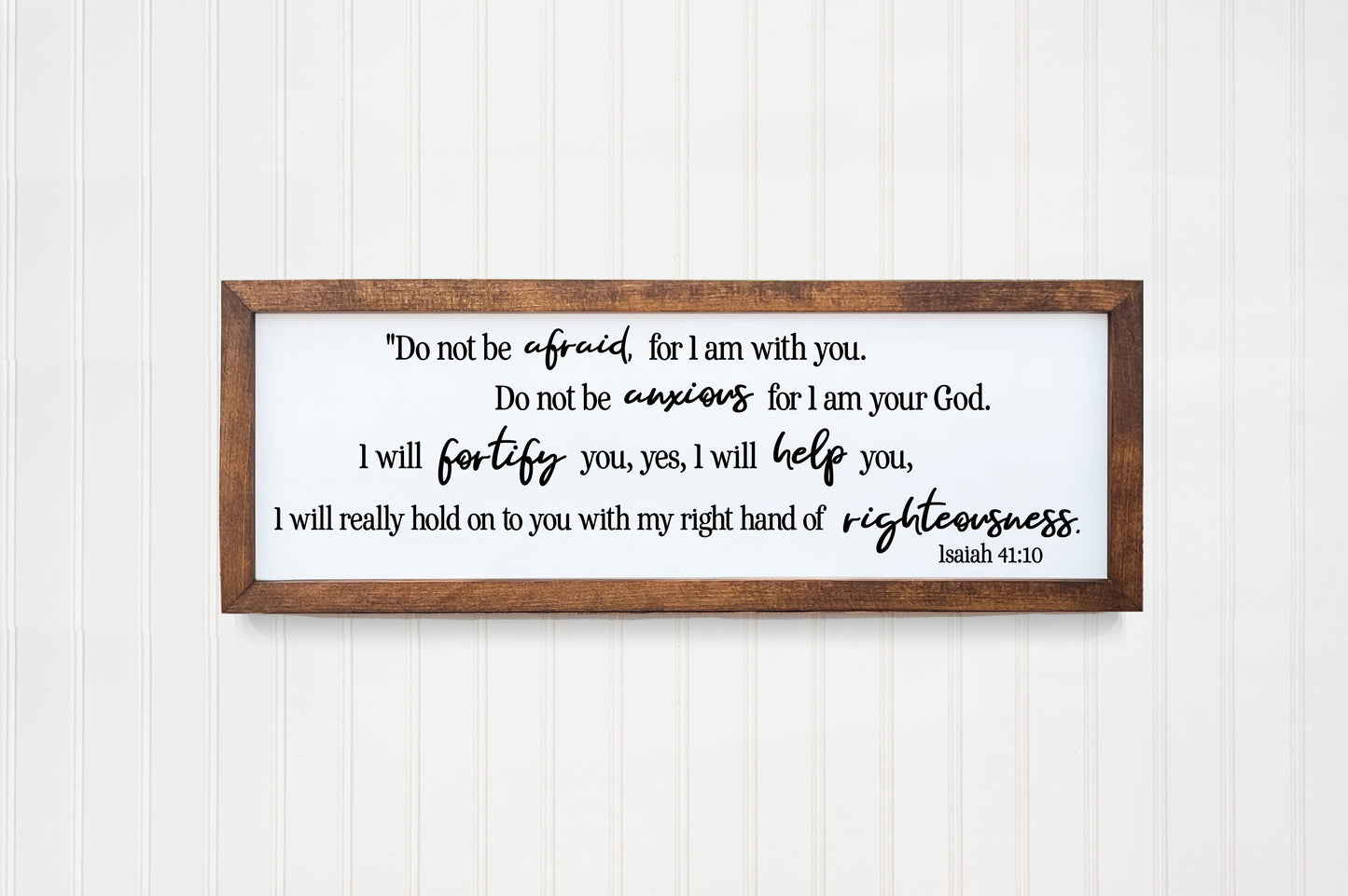 Wooden framed sign with biblical text on a white wall