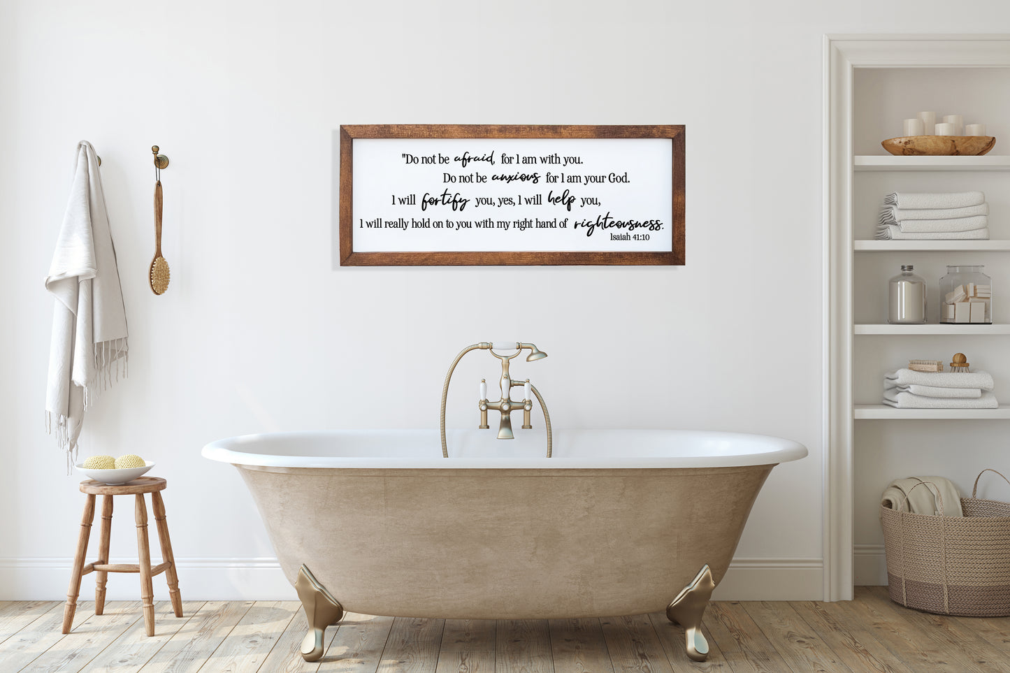 Bathroom with a freestanding bathtub, wooden stool, and framed text on the wall.